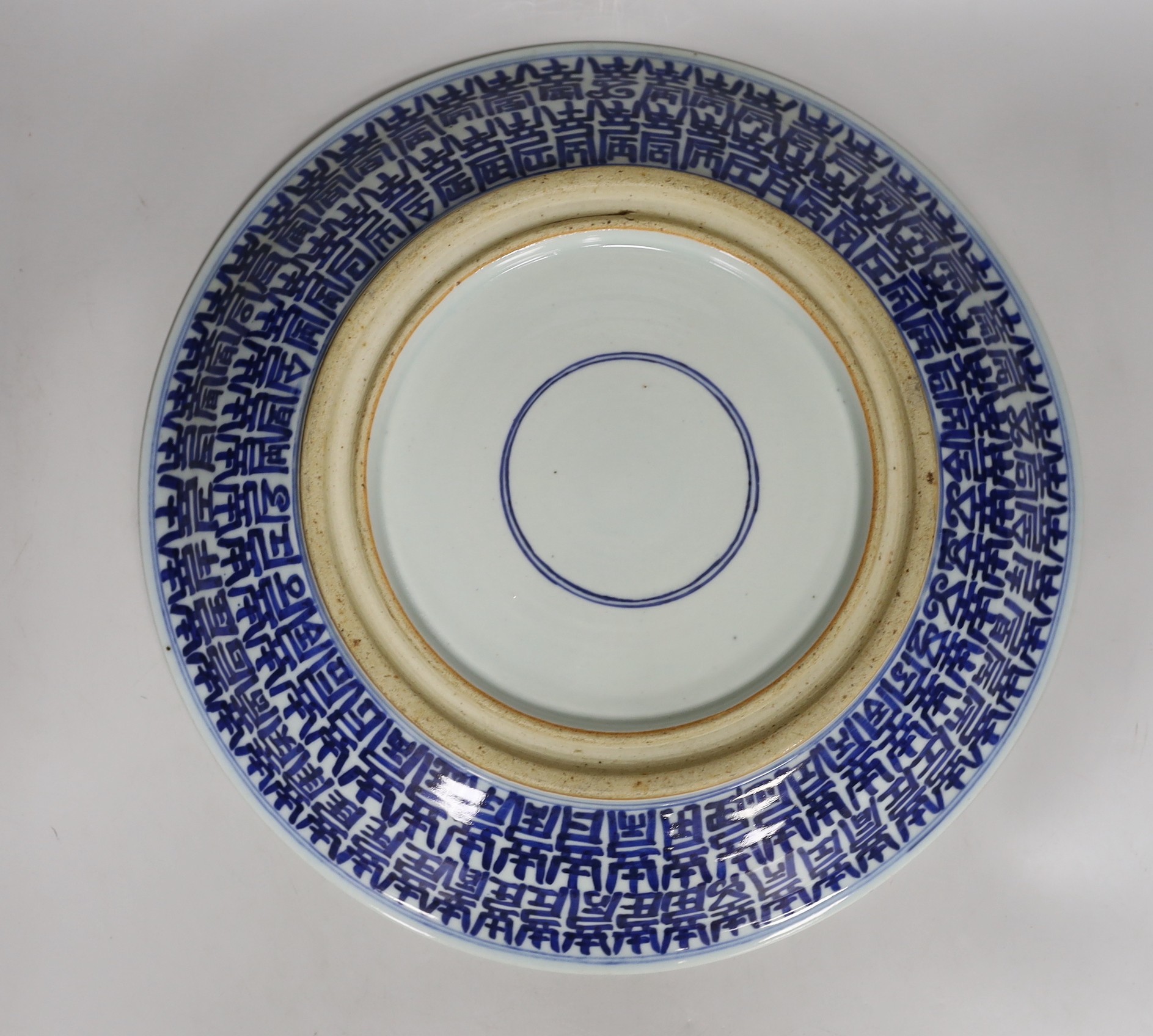 A Chinese enamelled porcelain ‘Hundred Shou’ dish, late 19th century, underglaze blue double circle and channel moulded foot, 37.5cm diameter